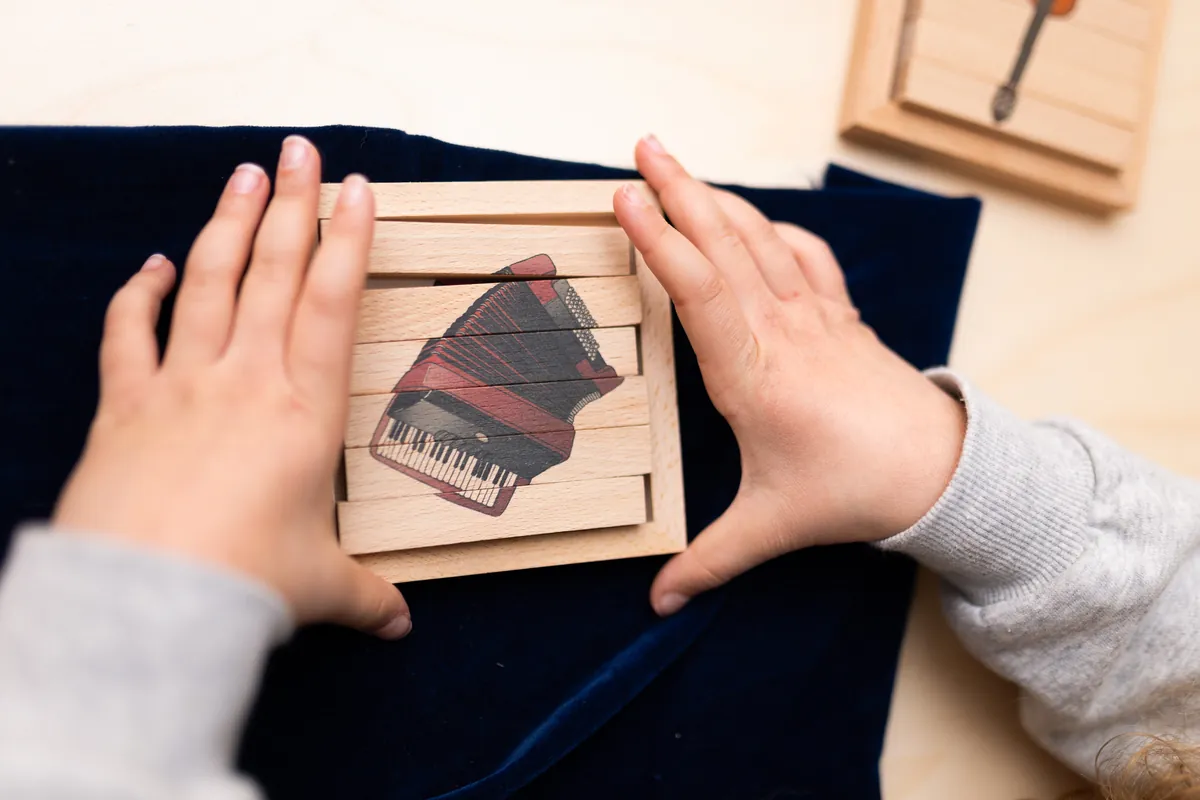 Enfant assemblant un puzzle pédagogique en bois